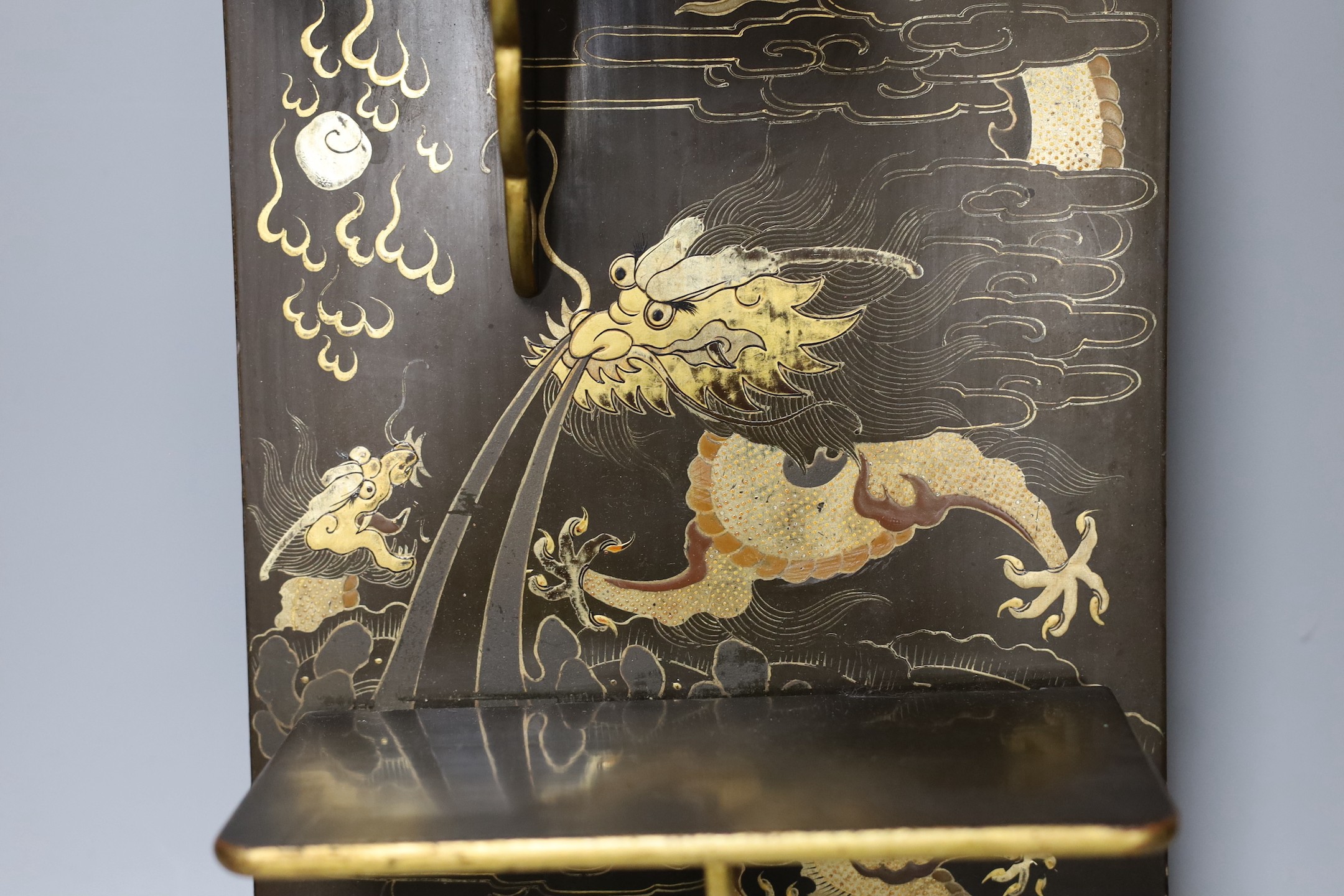 A Chinese lacquer ‘dragon’ wall shelf, 55x25cm